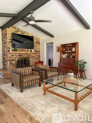 A living room with a fireplace and a television above it.