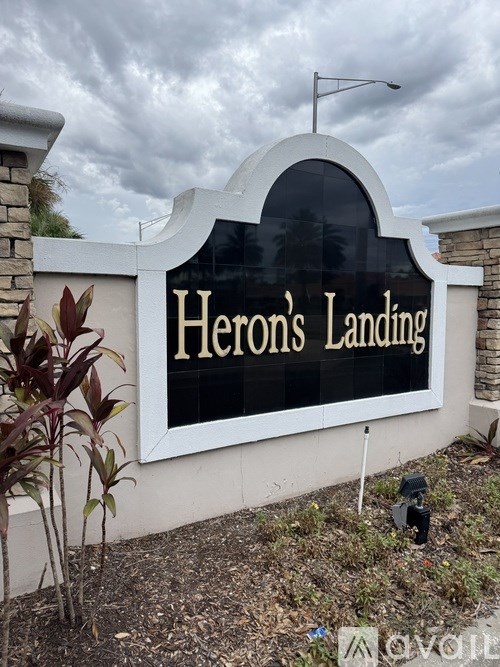 A sign that says Heron's Landing is displayed on a building.