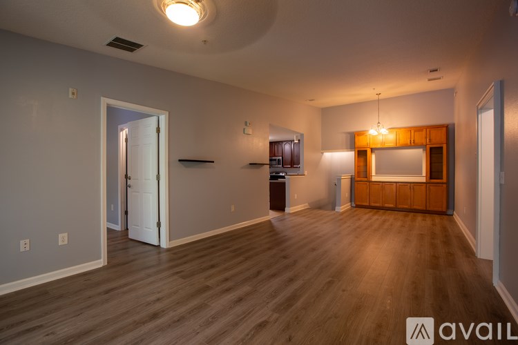A spacious room with wooden floors and a large mirror on the wall.