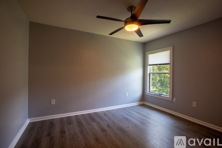 A room with a ceiling fan and a window.