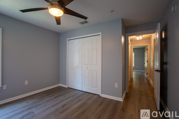 A room with a ceiling fan and a white door.