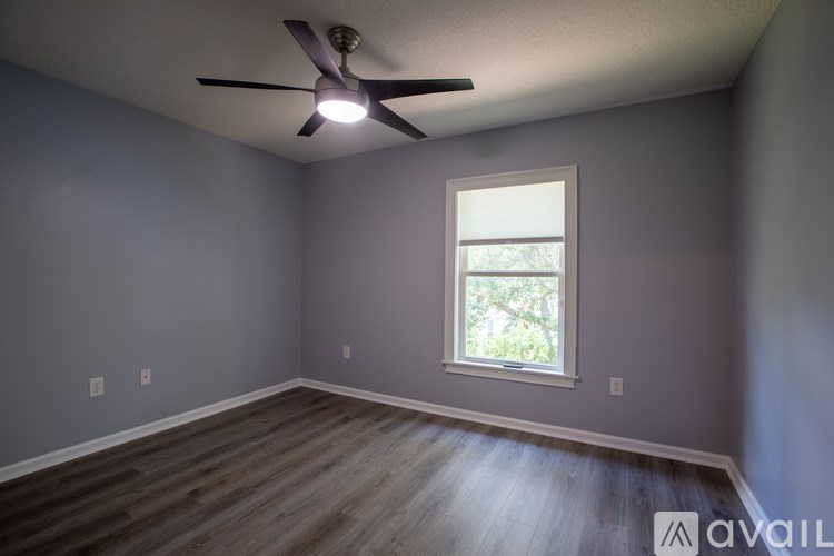 A room with a ceiling fan and a window.