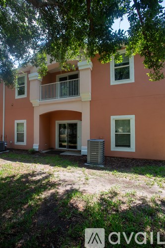 A two-story building with a balcony and two air conditioning units.