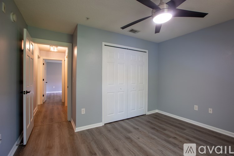 A room with a ceiling fan and a door.