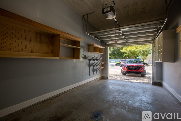 A parking garage with a red car in the background.