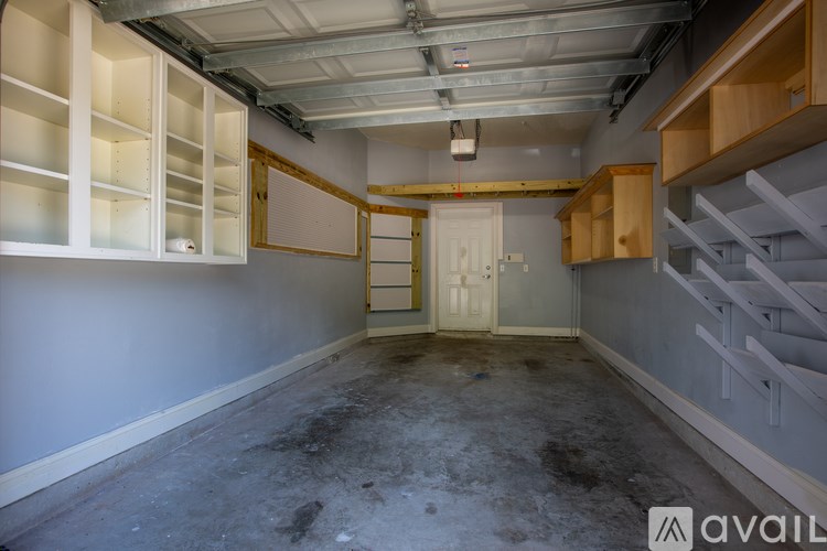 A room with a door and a window with a white wall and a floor with a lot of stains.