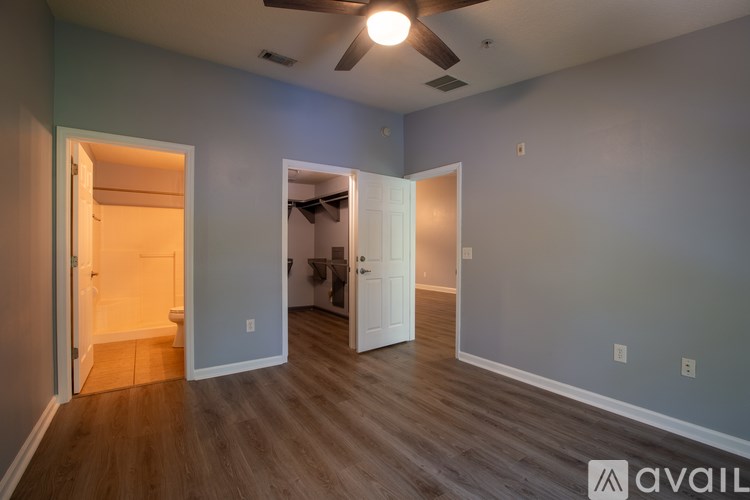 A room with a ceiling fan and wooden flooring.
