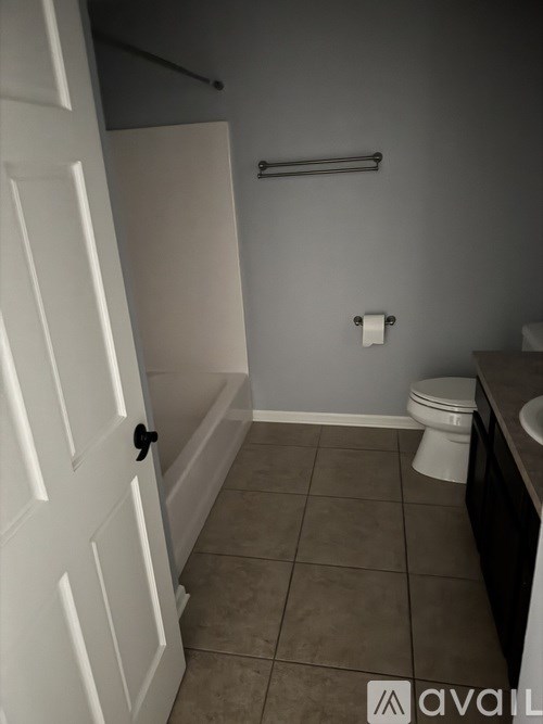 A bathroom with a toilet, sink, and a white door.