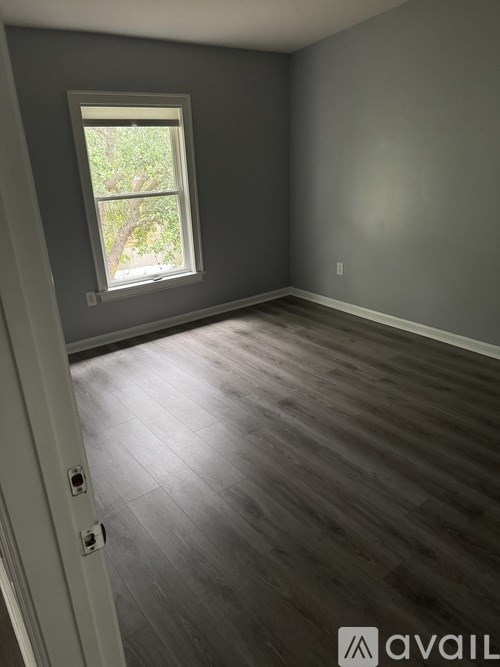 A room with a window and wooden flooring.