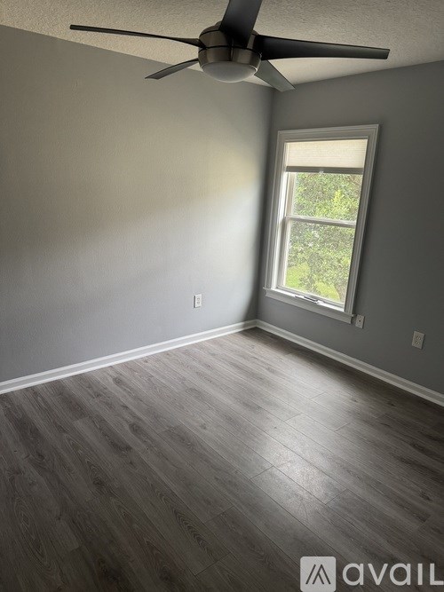 A room with a ceiling fan and a window.