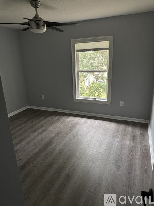 A room with a window and a ceiling fan.