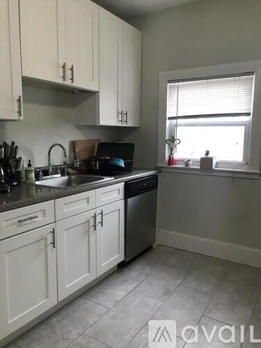 A kitchen with white cabinets and a window.