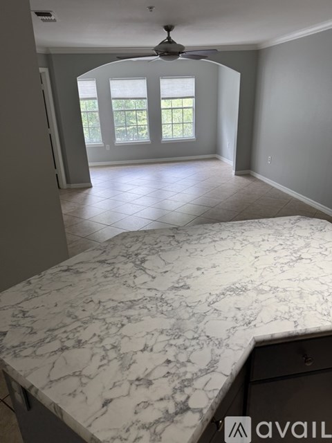 A room with a marble countertop and a ceiling fan.