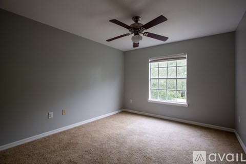 A room with a ceiling fan and a window.
