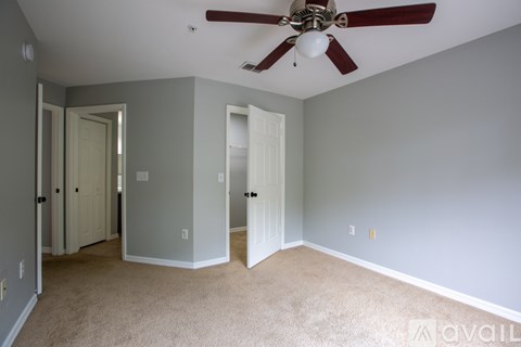 A room with a ceiling fan and carpeted floor.