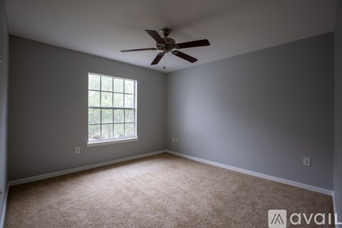 A room with a ceiling fan and a window.