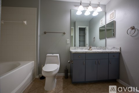 A bathroom with a toilet, sink, and bathtub.