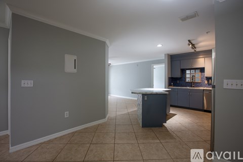 A kitchen area with a counter and cabinets is visible through a doorway.
