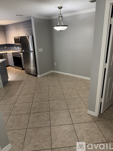 A kitchen with a refrigerator, oven, and sink.