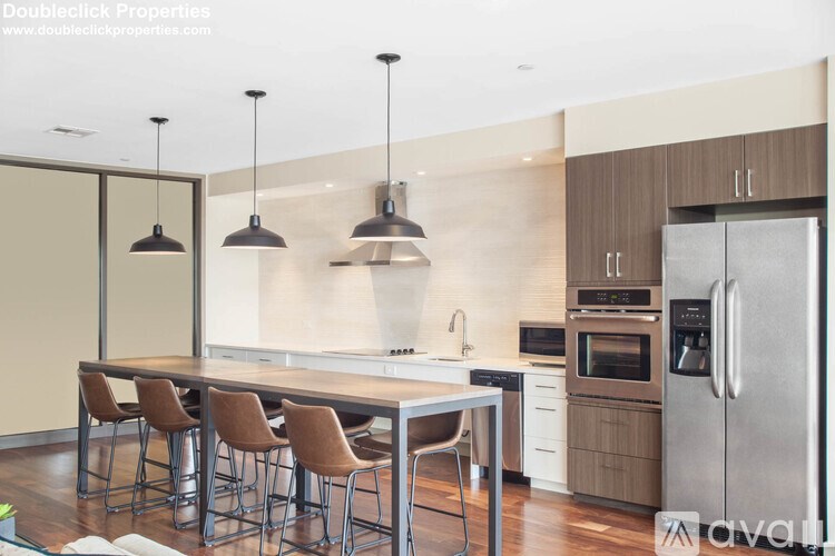 A modern kitchen with a dining table and chairs.