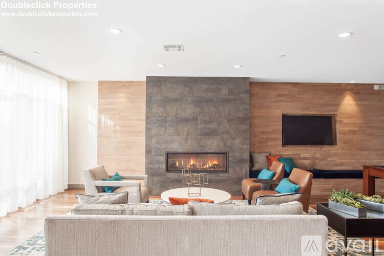 A modern living room with a fireplace and a flat screen TV mounted on the wall.