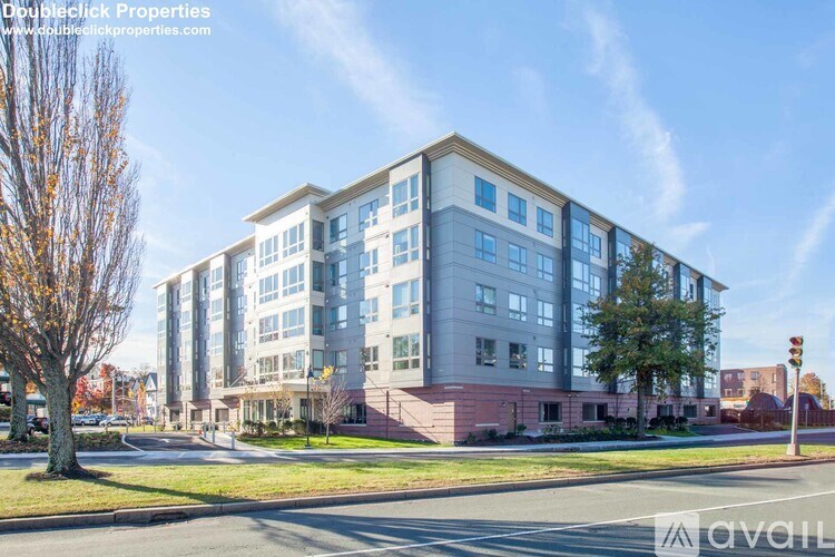 A multi-story building with a red brick facade and white trim is shown.