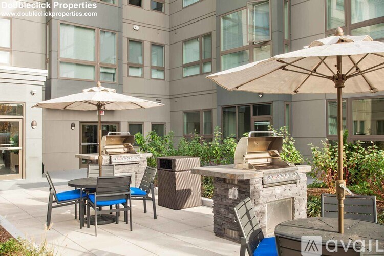 A patio with a table, chairs, and an umbrella is set up outside a building.