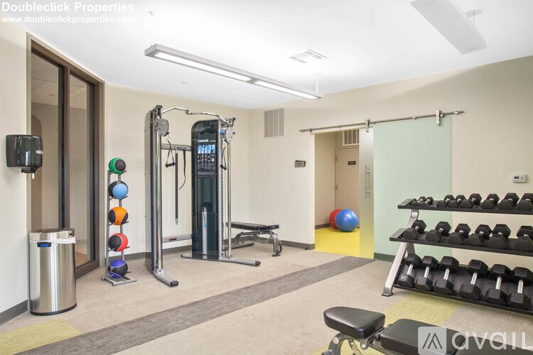 A gym with a variety of equipment including a treadmill, weights, and a balance ball.