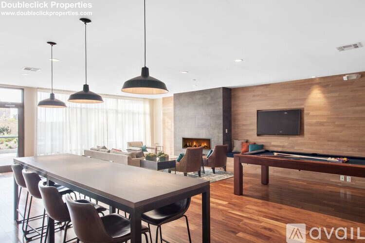 A modern dining room with a pool table and a television mounted on the wall.