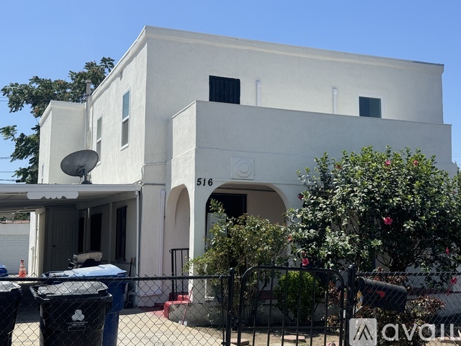 A white building with a satellite dish on the left side.