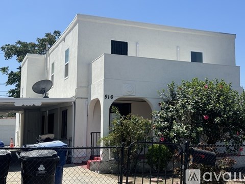 A white building with a satellite dish on the left side.