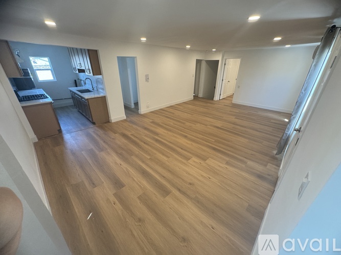 A room with wooden flooring and white walls is available for rent.