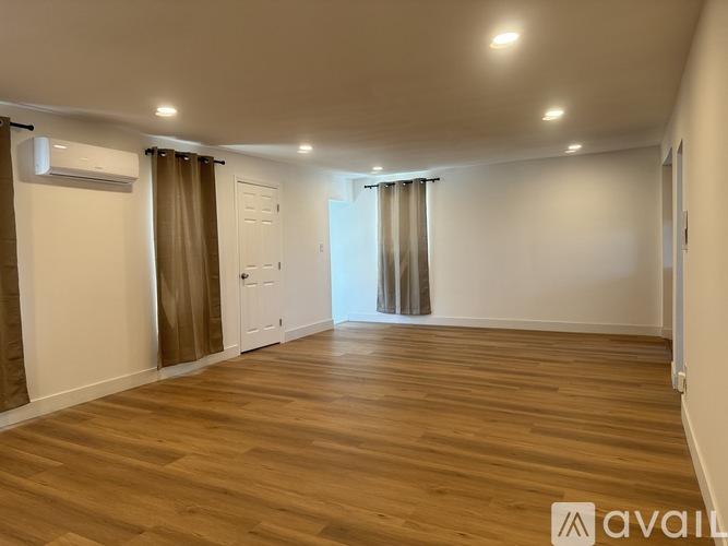 A room with wooden flooring and a white door.