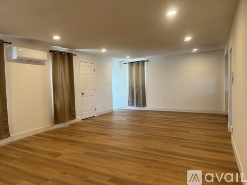 A room with wooden flooring and a white door.