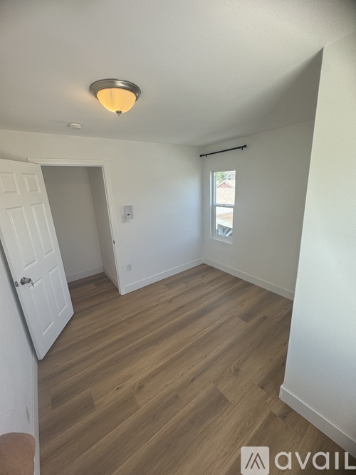 A kitchen area with wooden floors and cabinets.