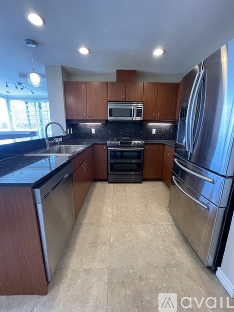 A kitchen with a refrigerator, oven, and microwave.