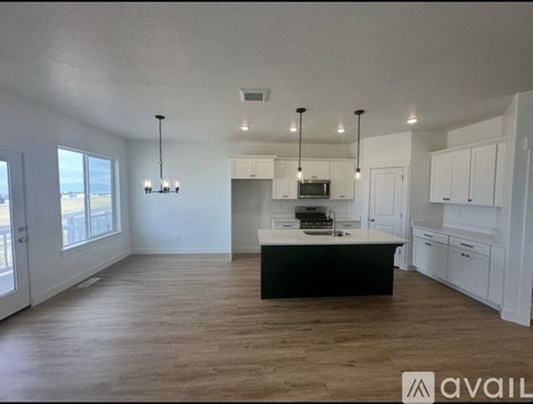 A spacious kitchen with white cabinets and a black island.