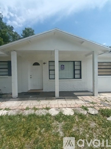 A white house with a porch and a door.