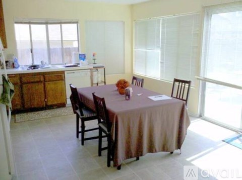 A dining room with a table set for four.