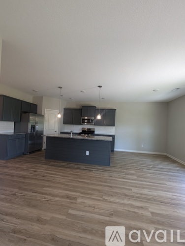 A kitchen with dark wood floors and a white ceiling.