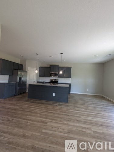 A kitchen with dark wood floors and a white ceiling.