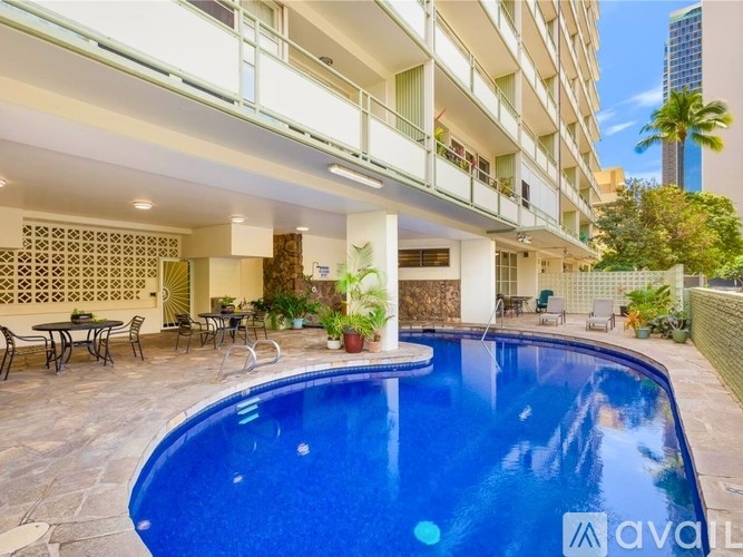 A large swimming pool is in the middle of a patio area.