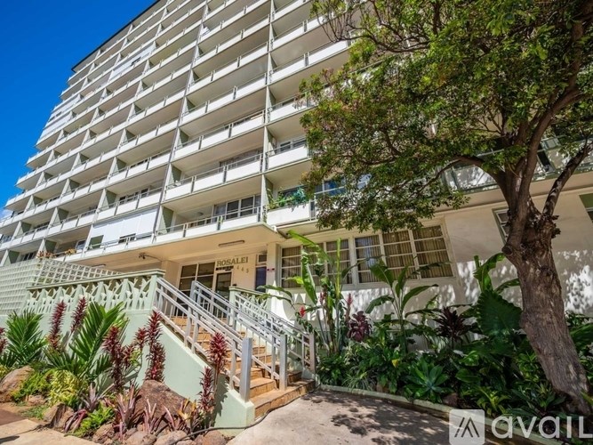A building with a white facade and a tree in front.
