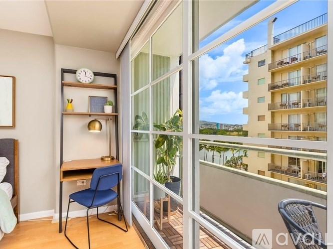 A balcony with a chair and a table is visible through a glass door.