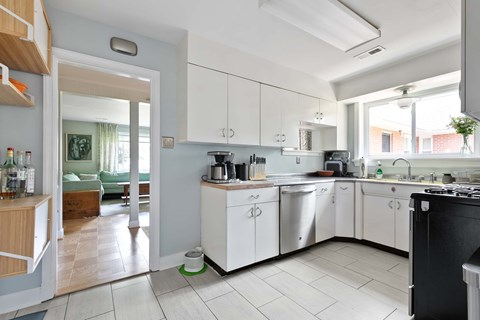 A modern kitchen with white cabinets and a black stove top.