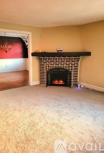 A living room with a fireplace and a painting on the wall.