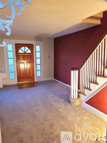 A room with a staircase and a door with a window.