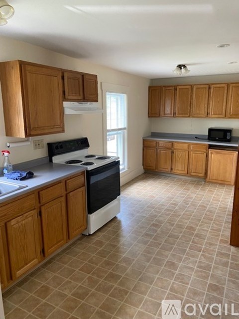 A kitchen with wooden cabinets and a black stove top oven.