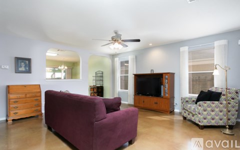 A living room with a purple couch and a television.