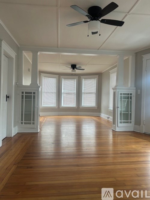 A room with wooden floors and a ceiling fan.